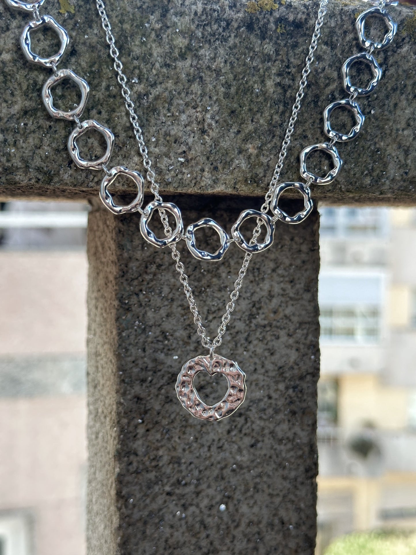 Amor necklace. Chain with heart pendant. Irregular circle pendant with a heart inside. 925 sterling silver alterego chunky jewelry. Next to the irregular circles silver necklace