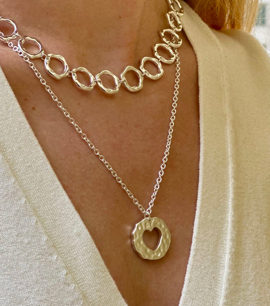 Amor necklace. Chain with heart pendant. Irregular circle pendant with a heart inside. 925 sterling silver alterego chunky jewelry. Next to the irregular circles silver necklace in model
